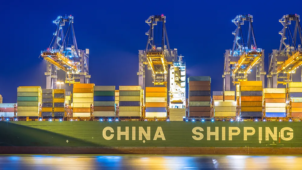Cargo containers at a busy shipping port in China managed by a freight forwarder