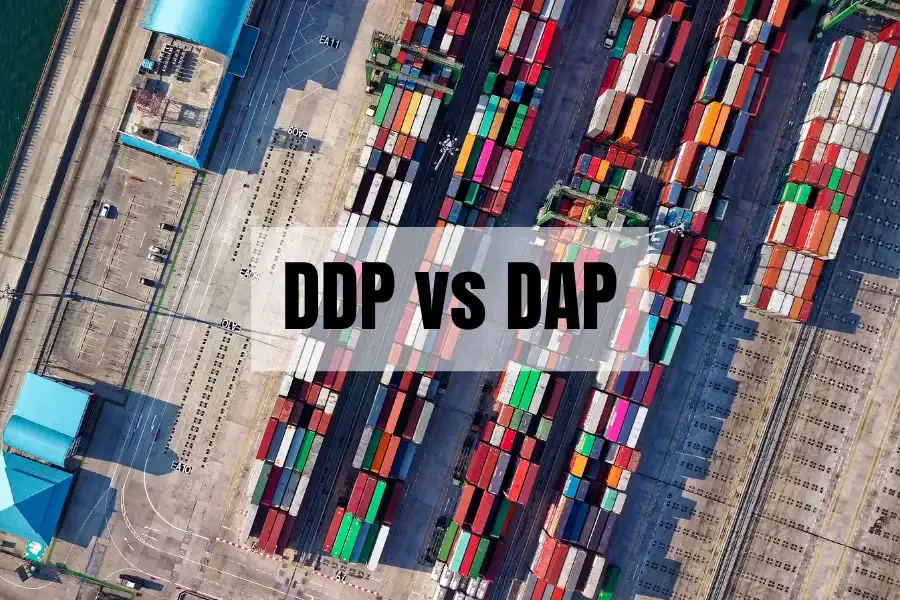 Una vista aérea de contenedores de transporte apilados y de colores, con el texto "DDP VS DAP" superpuesto, que representa una comparación de estos dos Incoterms para envíos a Alemania.